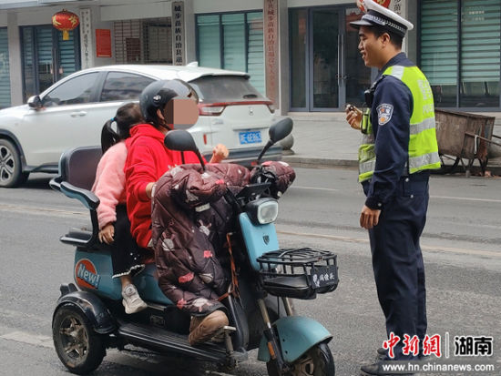 执勤交警耐心劝导未佩戴安全头盔的电动车、摩托车骑乘人员。 王祥志 摄 执勤交警耐心劝导未佩戴安全头盔的电动车、摩托车骑乘人员。 王祥志 摄