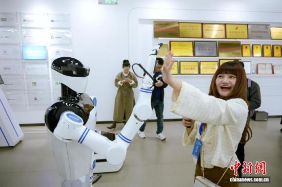 10月26日,在湖南比邻星科技有限公司展厅,东盟媒体人与人形机器人拍掌互动。中新社记者 杨华峰 摄 10月26日,在湖南比邻星科技有限公司展厅,东盟媒体人与人形机器人拍掌互动。中新社记者 杨华峰 摄