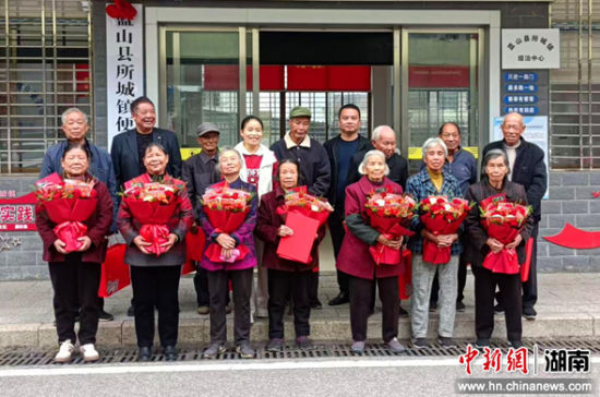 工作人员为每对金婚夫妇送上鲜花和精心准备的纪念礼品。蓝山县委宣传部供图 工作人员为每对金婚夫妇送上鲜花和精心准备的纪念礼品。蓝山县委宣传部供图