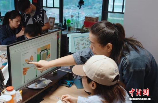 2025年9月22日,戴翎怡(前排右)与团队讨论文创产品设计。王鑫 摄 2025年9月22日,戴翎怡(前排右)与团队讨论文创产品设计。王鑫 摄