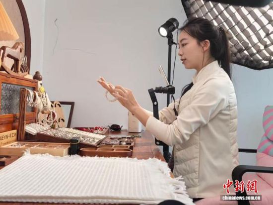 湖南永兴县中国银都文创园电商直播基地内,崔雪飘在直播间展示银饰产品。中新网记者 鲁毅 摄 湖南永兴县中国银都文创园电商直播基地内,崔雪飘在直播间展示银饰产品。中新网记者 鲁毅 摄