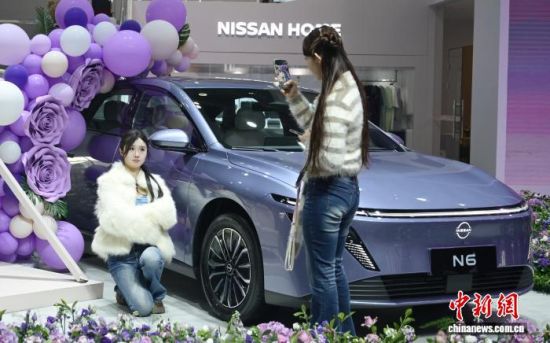 年轻人在车企布置的打卡区拍照。中新网记者 唐小晴 摄 年轻人在车企布置的打卡区拍照。中新网记者 唐小晴 摄